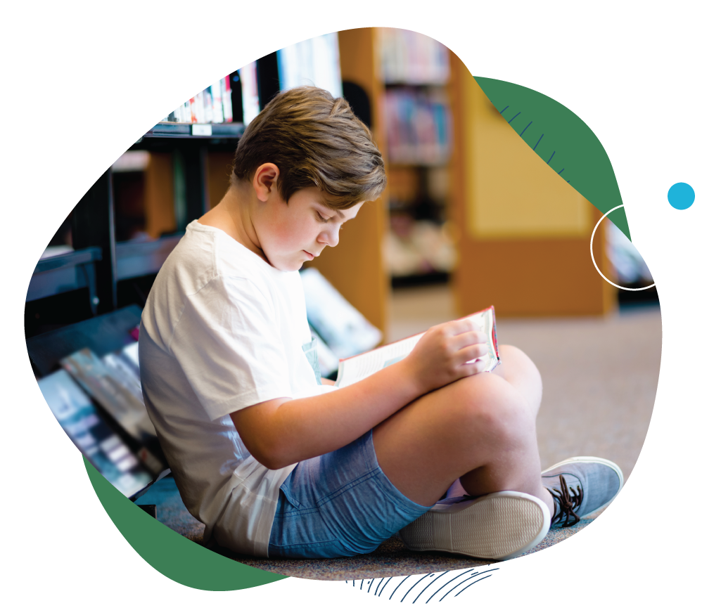 A child sitting in the library reading